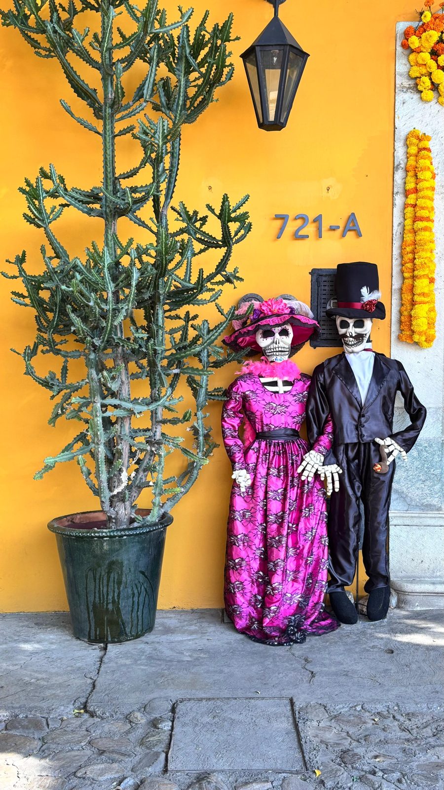 Catrinas diante de um muro amarelo
